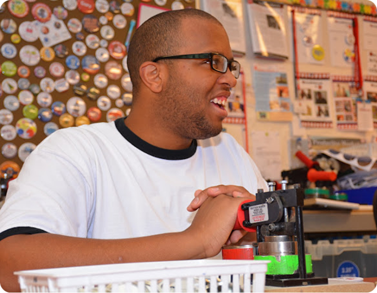 HB Threads employee using heat press for customized magnets